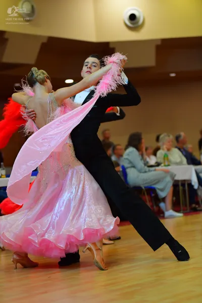 Dancesport competitor: Female dancer: light pink voluminous ballgown with a sparkly bodice and feathery