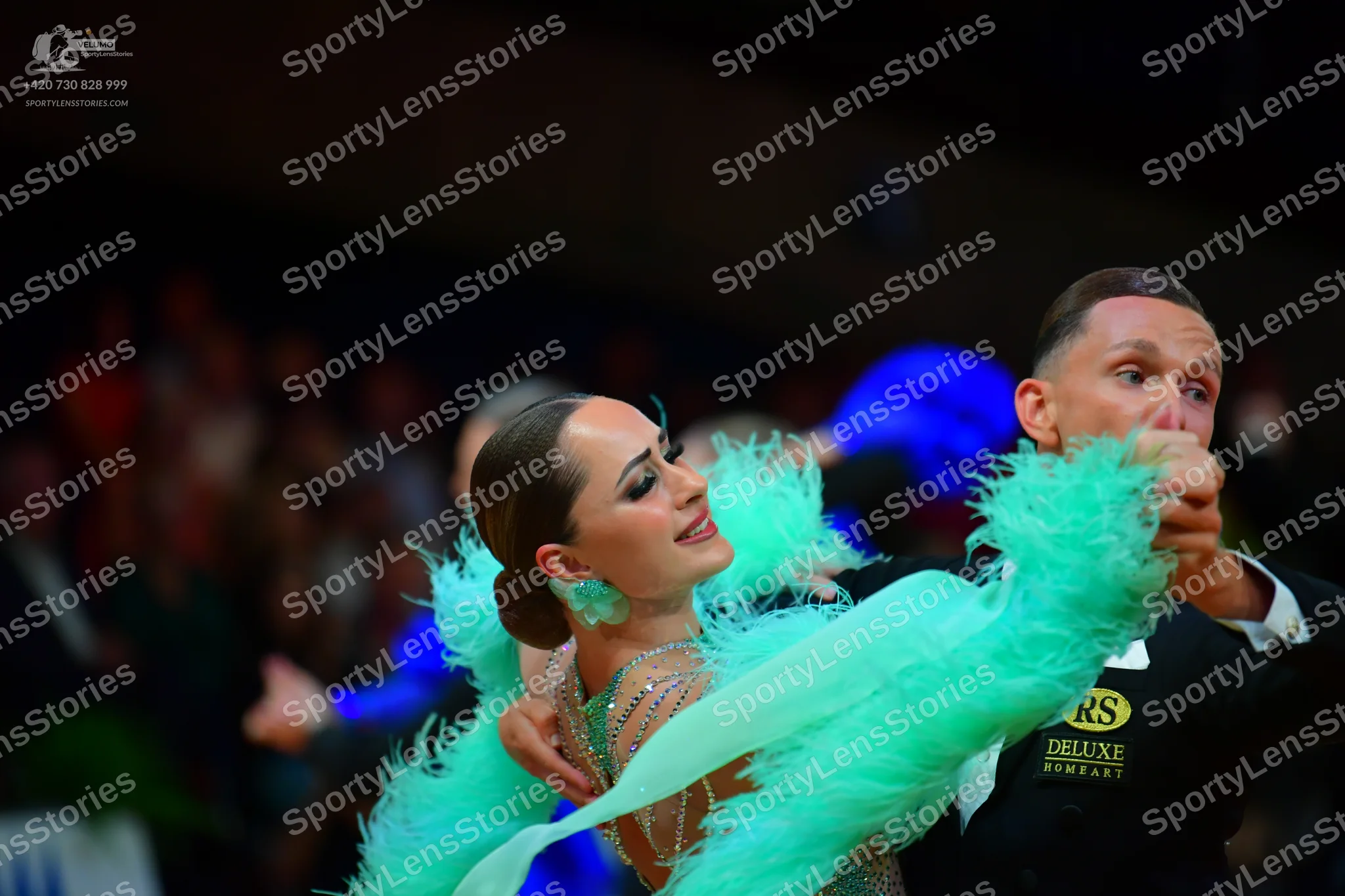 Dancesport competitor: Male dancer: black long-sleeved top with gold "RS DELUXE" lettering