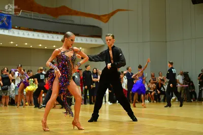 Dancesport competitor: Main female dancer: dark-colored Latin dress with multi-colored sequins in shade