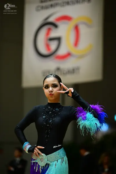 Dancesport competitor: Female dancer: black long-sleeved Latin dance bodysuit with black sequins on the