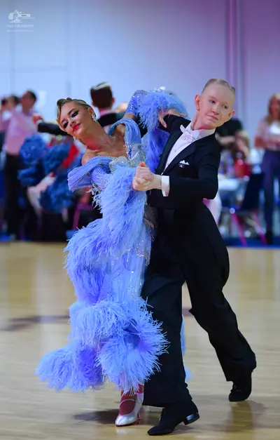 Dancesport competitor: Female dancer: light blue latin dress with sequins and large blue feathers