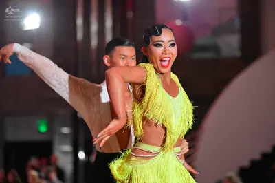 Dancesport competitor: Female dancer: yellow-green Latin dress with fringe and cutouts at the waist