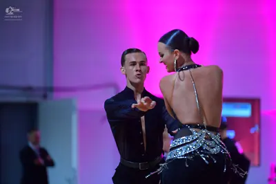 Dancesport competitor: Male dancer: black long-sleeved shirt and black trousers with a black belt