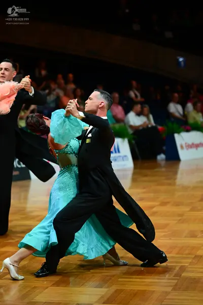 Dancesport competitor: Male dancer: black tailcoat-style suit with black trousers and black shoes