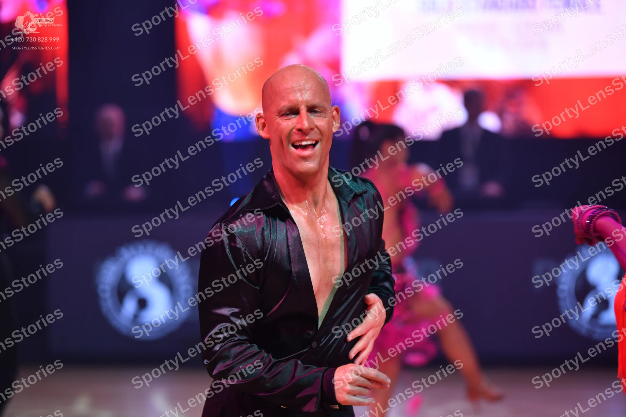 Dancesport competitor: Male dancer: black satin-like long-sleeved shirt, partially unbuttoned