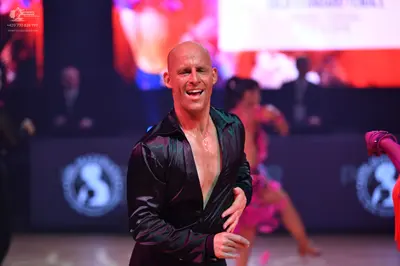 Dancesport competitor: Male dancer: black satin-like long-sleeved shirt, partially unbuttoned