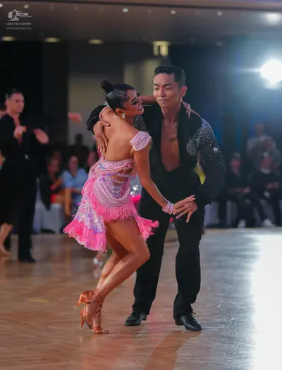 Dancesport competitor: Female dancer: pink and lavender sequined Latin dance dress with long pink fring