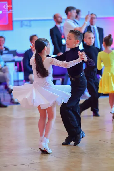 Dancesport competitor: Female dancer: white long-sleeved dress with lace sleeves and a flared skirt