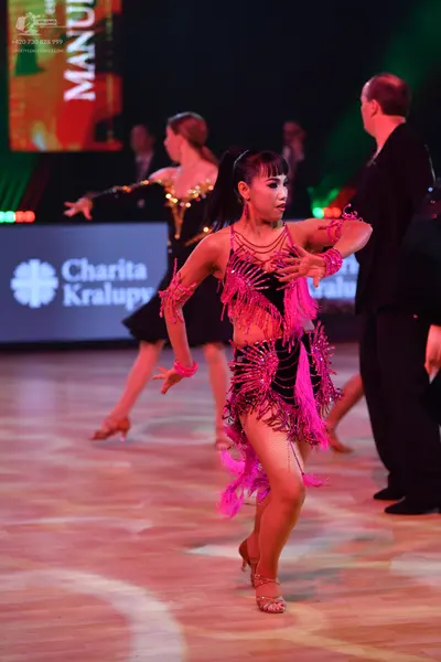 Dancesport competitor: Female dancer 1: pink latin dress with long fringe