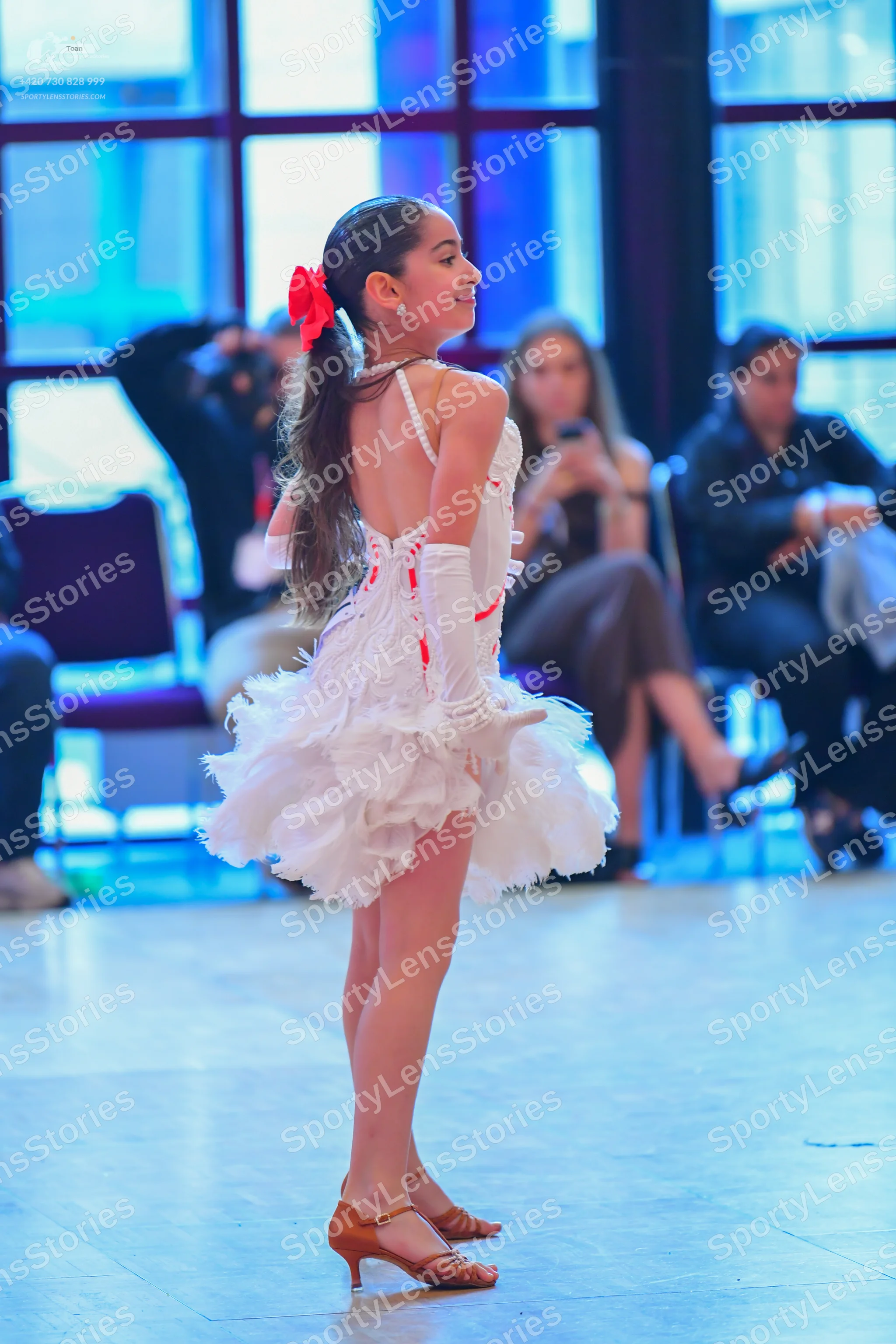 Dancesport competitor: Female dancer: white latin dress with many ruffles and red accents, white gloves