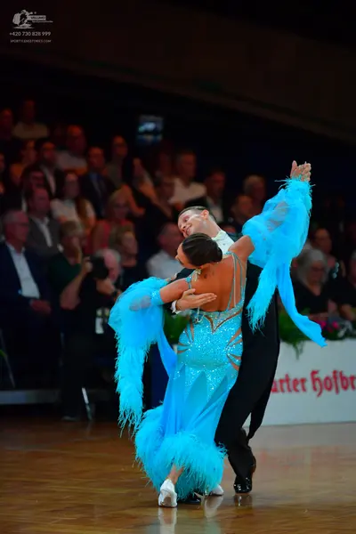 Dancesport competitor: Female dancer: cyan latin dress with sequins on the bodice and long blue fringe 