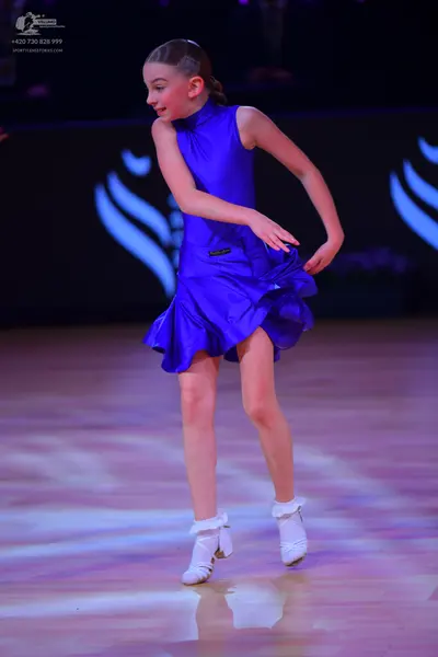 Dancesport competitor: Female dancer: blue, sleeveless, short satin-like dress with a ruffled skirt and