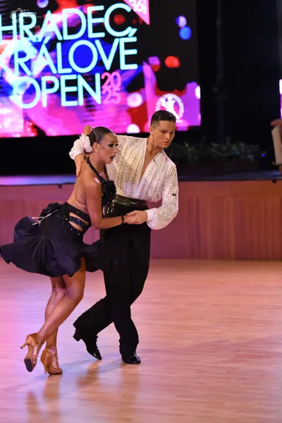 Dancesport competitor: Male dancer: white textured lace-patterned long-sleeved shirt and black trousers