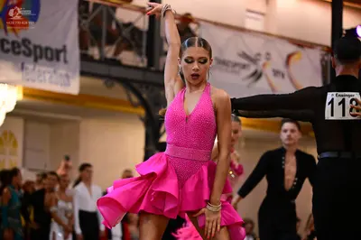 Dancesport competitor #118: Female dancer: bright pink latin dress with a ruffled skirt and a sequined bodic