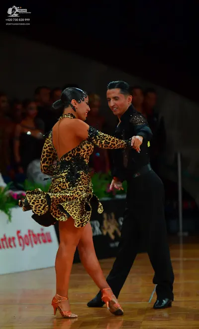 Dancesport competitor: Female dancer: leopard print latin dress with long sleeves, an open back, and bl