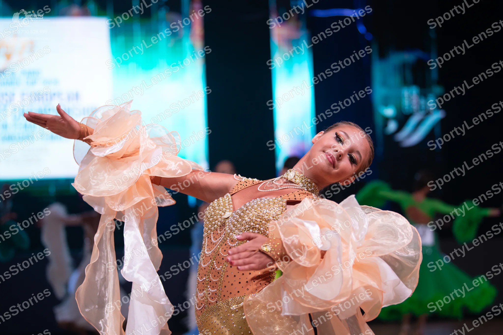 Dancesport competitor: Female dancer: peach-colored Latin dance dress with a sequin-embellished bodice