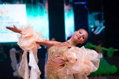 Dancesport competitor: Female dancer: peach-colored Latin dance dress with a sequin-embellished bodice 