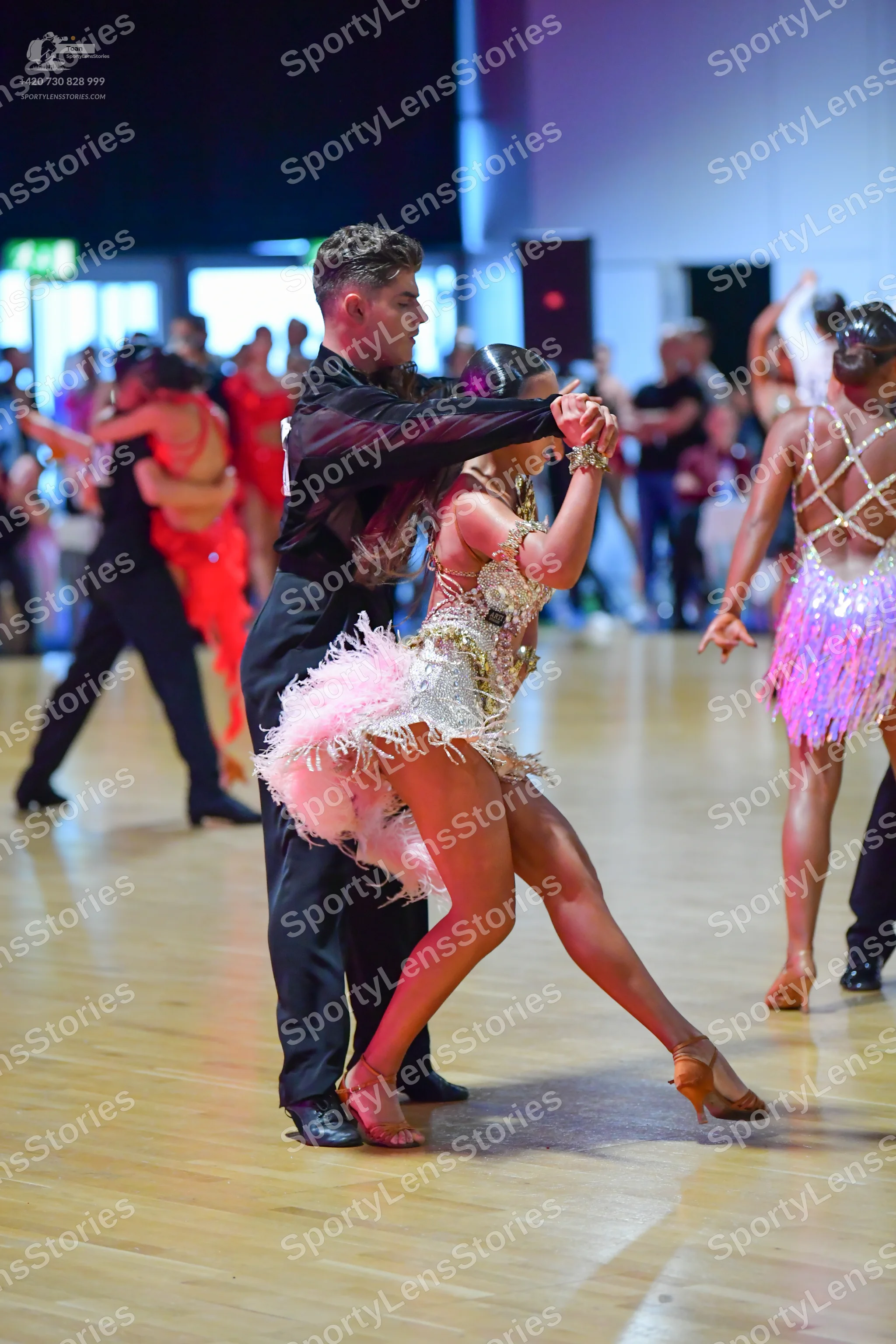 Dancesport competitor: Male dancer (center): black long-sleeved shirt and black trousers