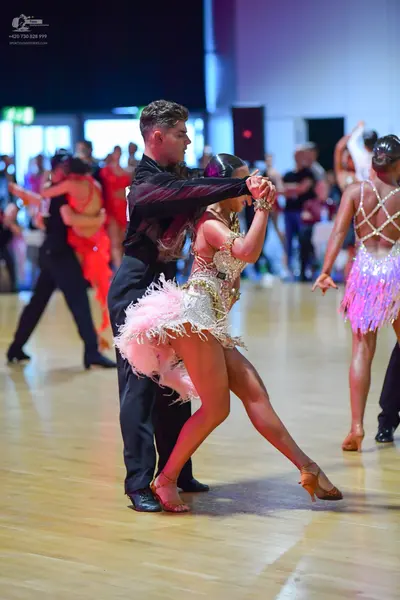Dancesport competitor: Male dancer (center): black long-sleeved shirt and black trousers