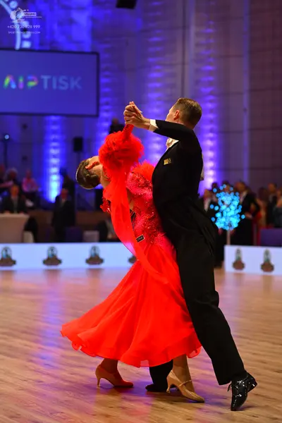 Dancesport competitor: Female dancer: red ballroom dress with a voluminous, flowing skirt and a texture