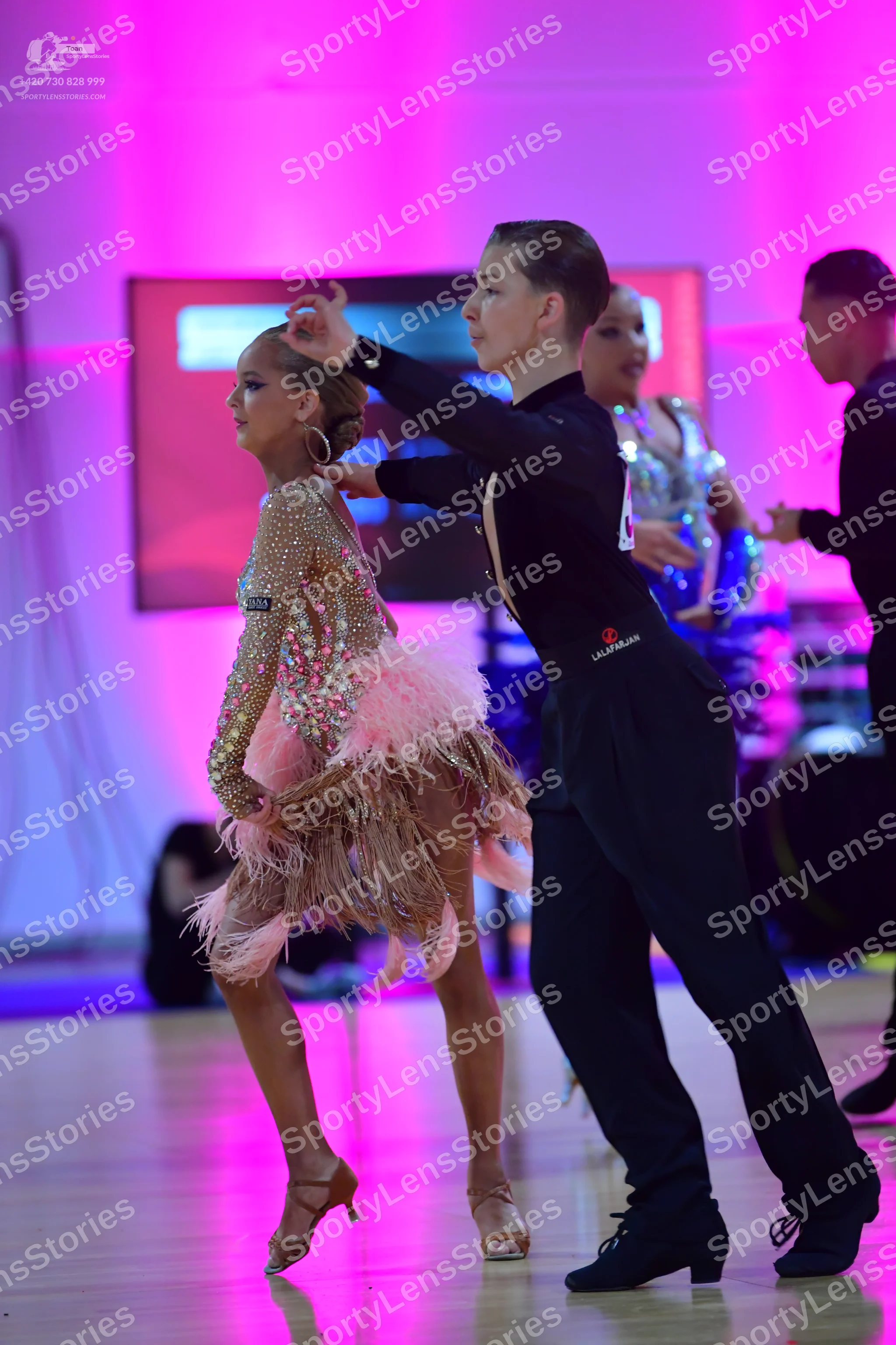 Dancesport competitor: Female dancer (foreground): nude-colored latin dress embellished with sequins an