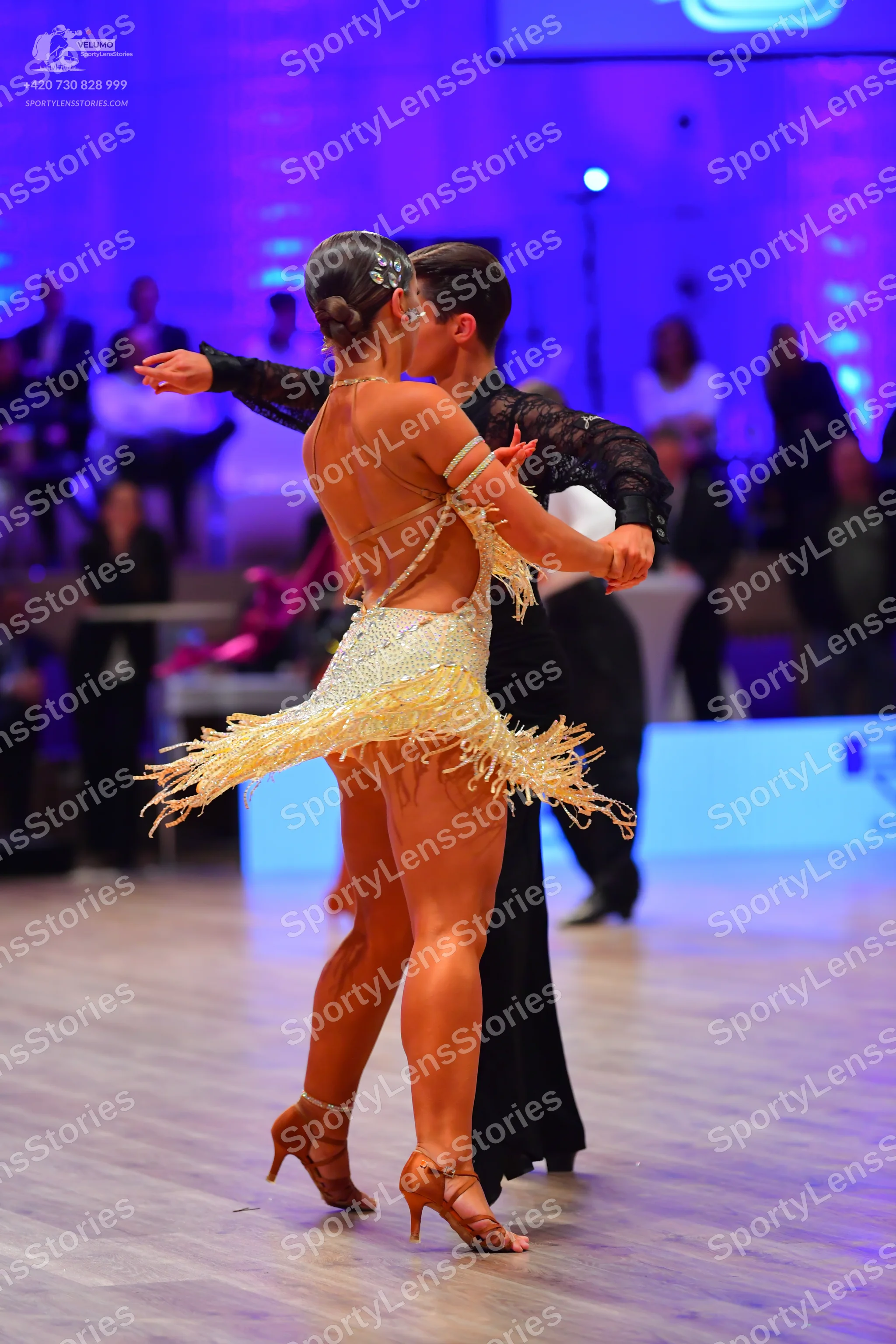 Dancesport competitor: Female dancer: champagne-colored Latin dress embellished with sequins, featuring