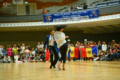 Dancesport competitor: Male dancer: blue suit jacket, white shirt, black tie, and black trousers