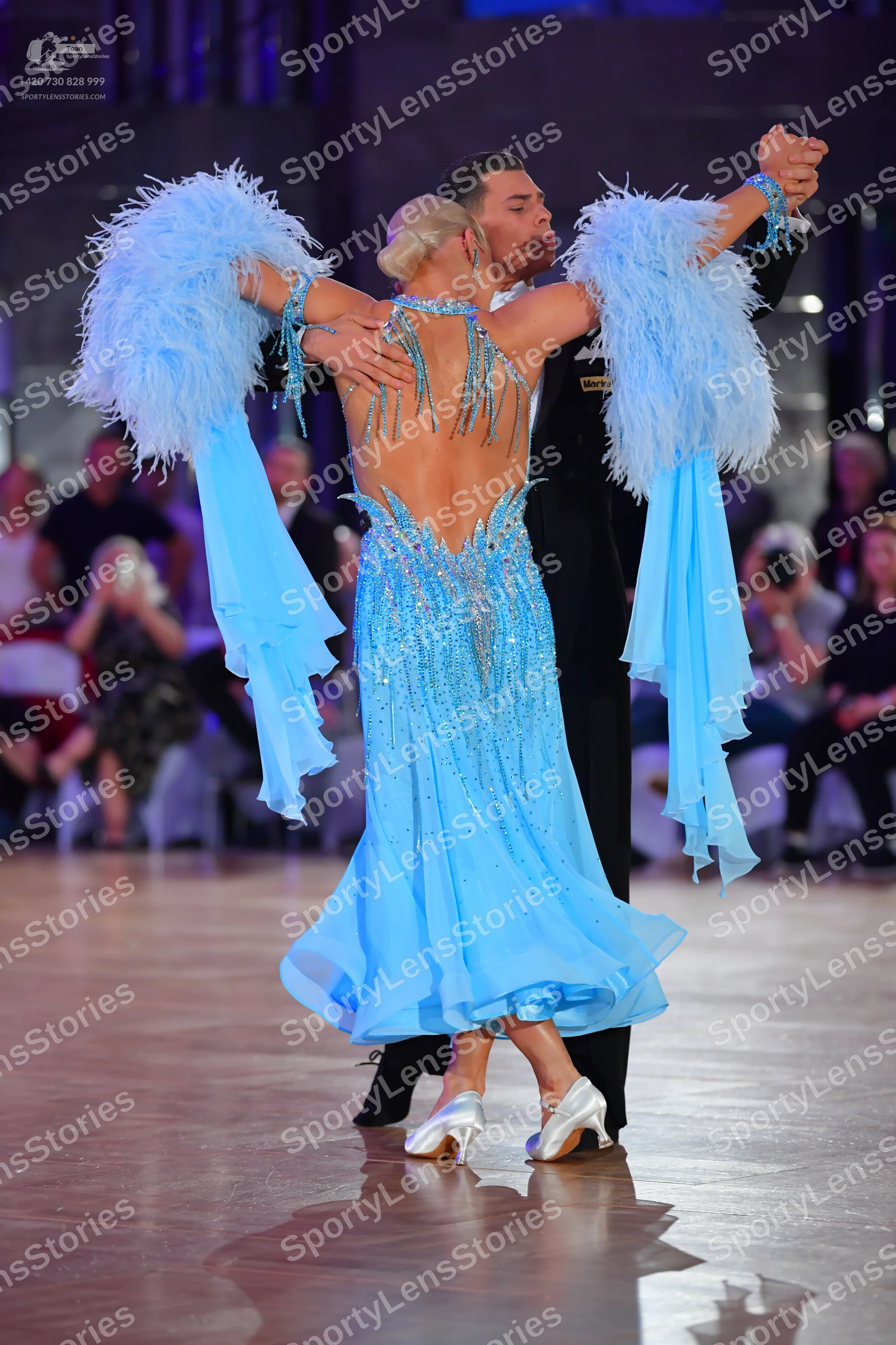 Dancesport competitor: Female dancer: light blue ballroom dress with sequins, a backless design, and la