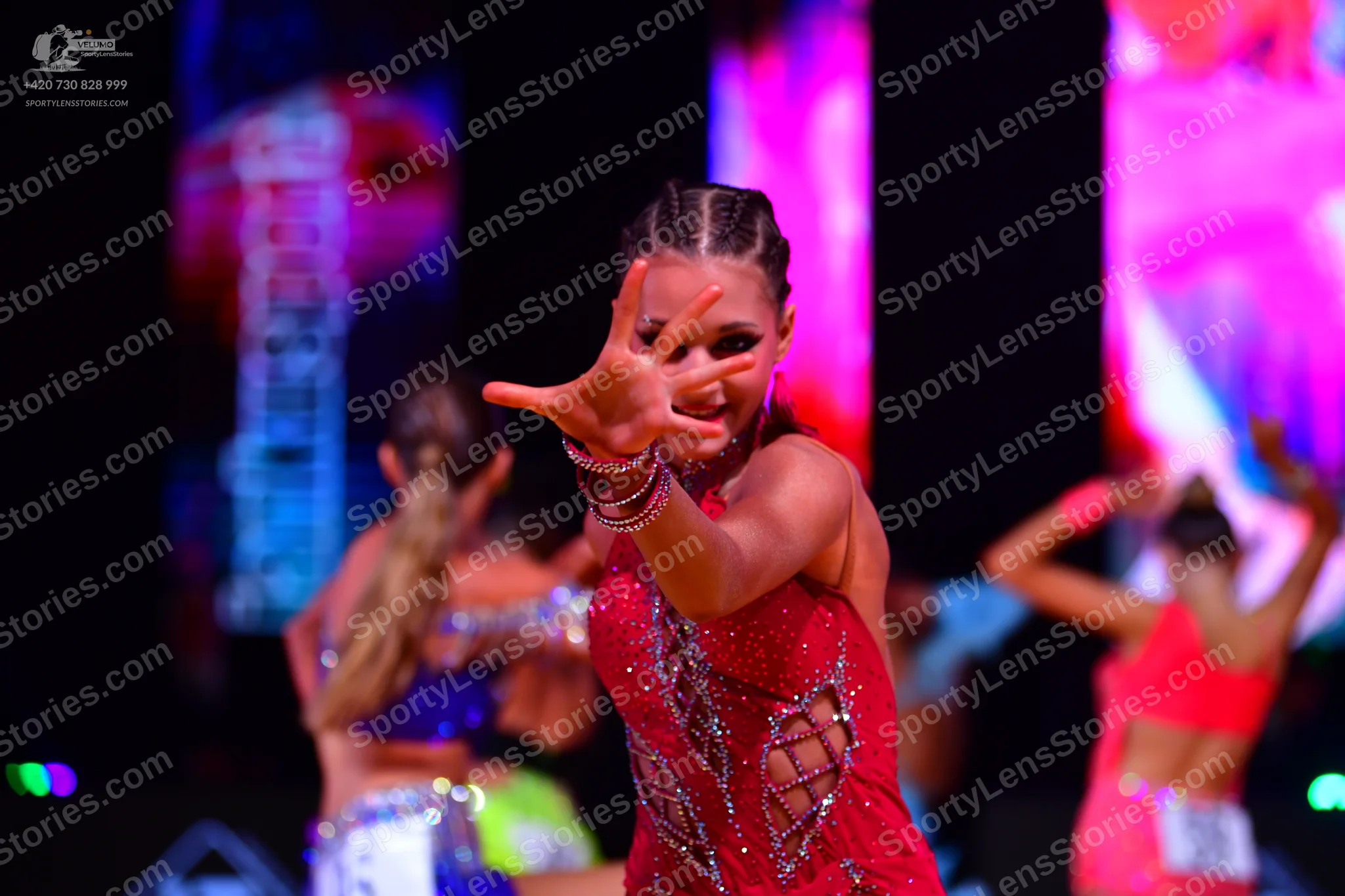 Dancesport competitor: Main dancer: red sequined Latin dress with side cutouts and lace-up detail