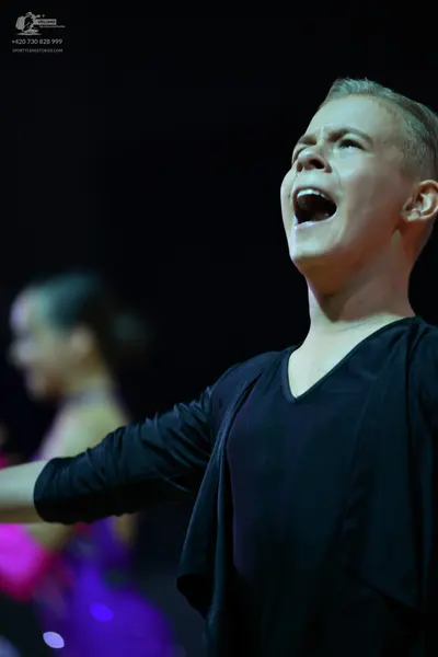 Dancesport competitor: Male dancer: black V-neck top and black outer layer