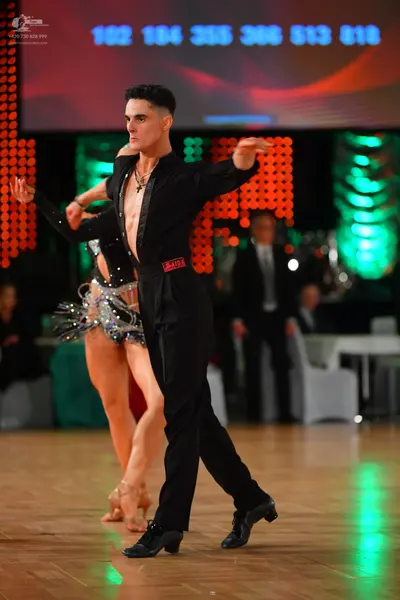 Dancesport competitor: Male dancer: black long-sleeved shirt, open at the chest, and black trousers, we
