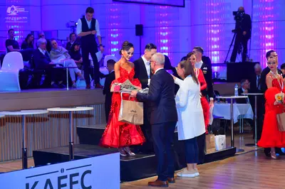 Dancesport competitor: Female dancer: red voluminous ballgown with shimmering fabric