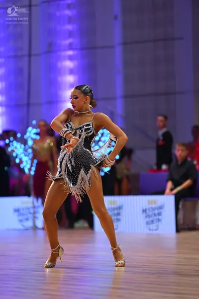 Dancesport competitor: Main female dancer: black Latin dance dress with silver sequins and long silver 