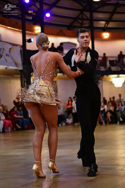 Dancesport competitor: Female dancer: gold sequined latin dress with fringe and thin straps