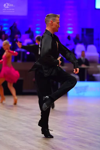 Dancesport competitor: Male dancer: black satin-like long-sleeved shirt and black trousers