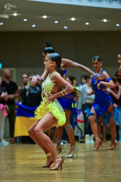 Dancesport competitor: Female dancer 1: lime green/yellow latin dress with sequins and yellow fringe, w