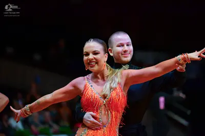 Dancesport competitor: Female dancer: orange/coral Latin dress with sequins and fringe