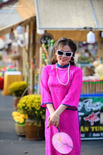 Dancesport competitor: Female dancer: bright pink long-sleeved Áo dài with teal trim on the collar and 