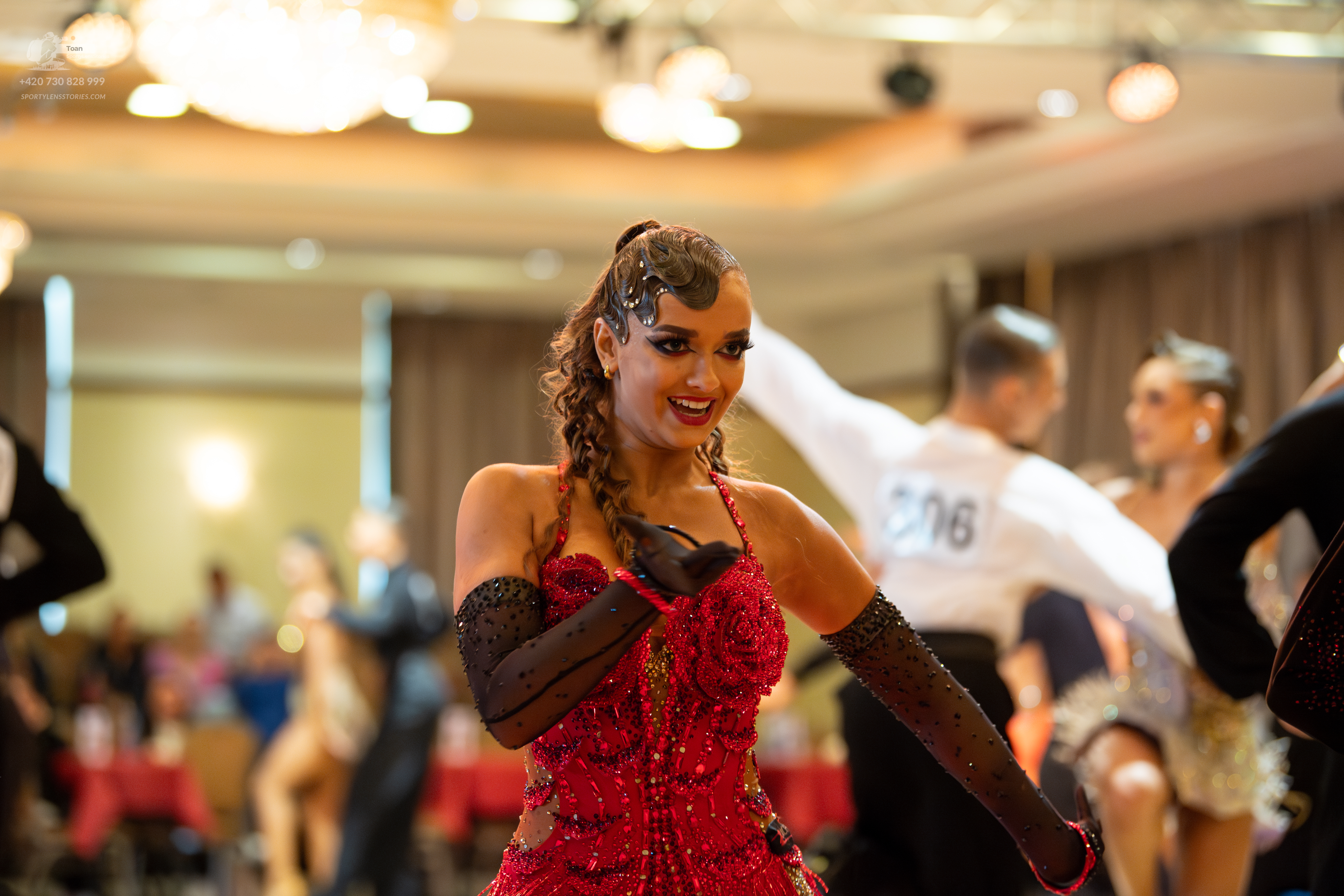 Dancesport competitor #206: Female dancer in foreground: red Latin dress with sequins and long black gloves