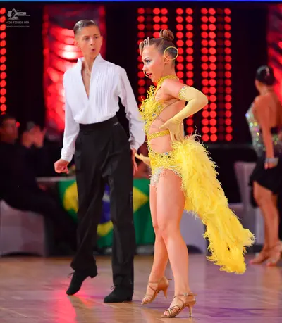 Dancesport competitor: Male dancer: white long-sleeved shirt with a deep V-neck and black trousers