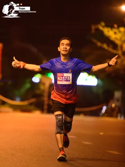 Marathon runner #42575: Runner 1: blue and red gradient jersey, black shorts, dark running shoes with re