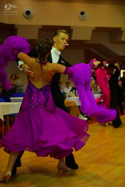 Dancesport competitor: Female dancer: purple latin dress with a sequined bodice, backless design, and l
