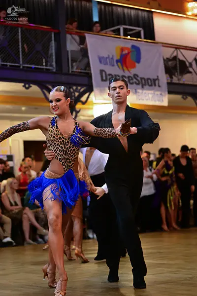 Dancesport competitor: Male dancer: black long-sleeved Latin dance shirt and matching black trousers