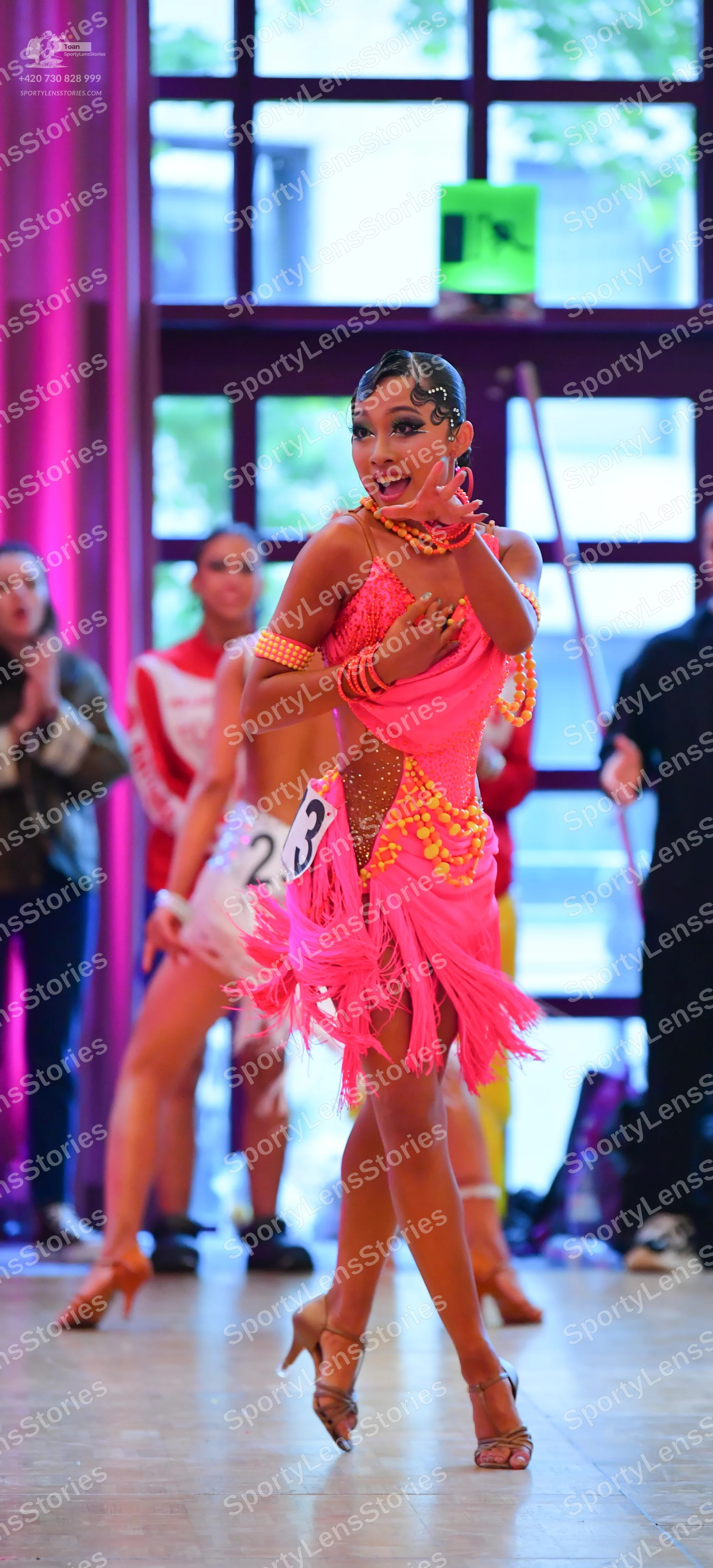 Dancesport competitor #23: Female dancer: pink latin dress with fringe, gold sequin embellishments, and mes