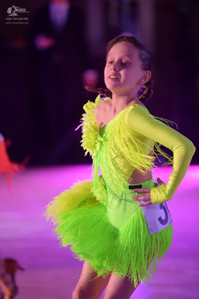 Dancesport competitor: Female dancer: bright neon green/lime green latin dress with long sleeves and ex