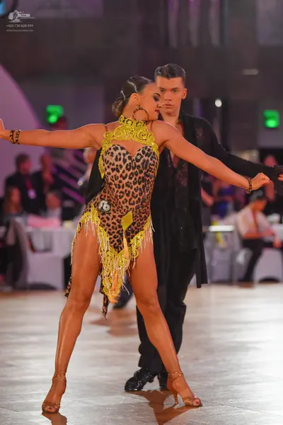 Dancesport competitor: Female dancer: leopard print Latin dance costume with lime green/yellow trim and