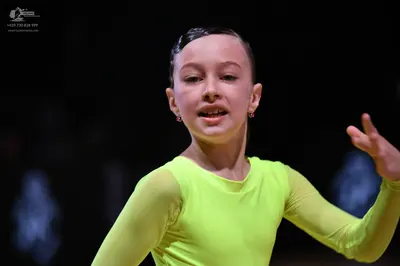 Dancesport competitor: Female dancer: lime green long-sleeved dance top made of smooth fabric