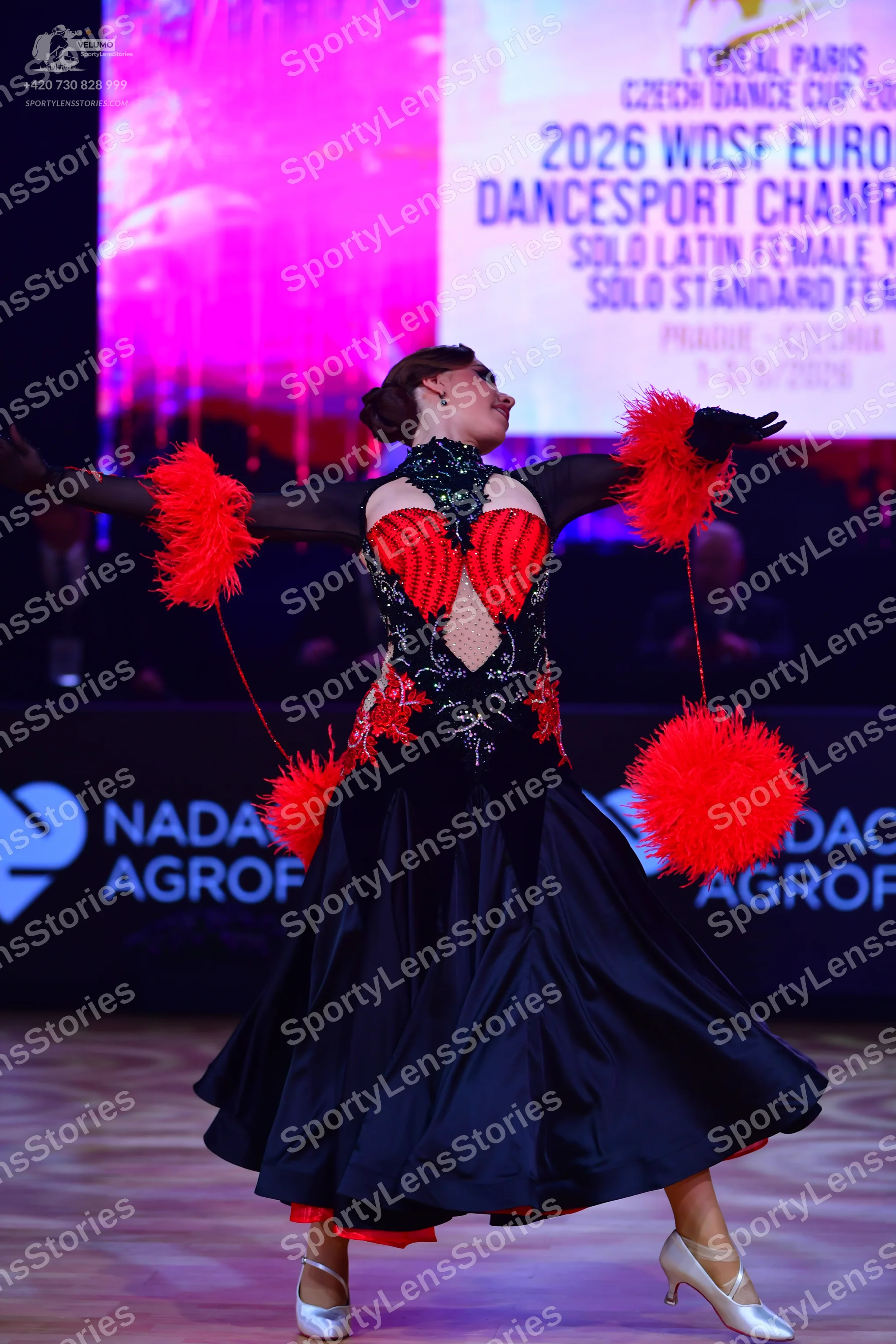 Dancesport competitor: Female dancer: black and red ballgown with a voluminous black satin skirt featur