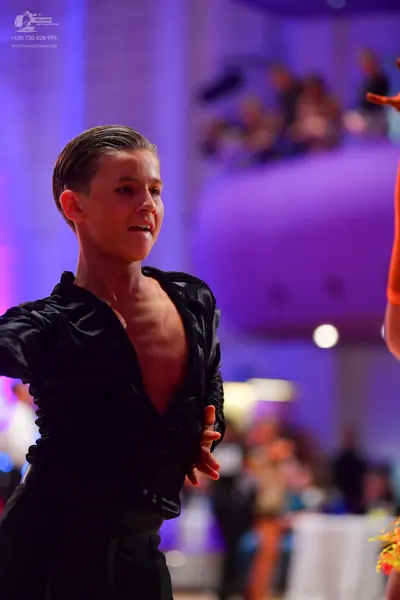 Dancesport competitor: Male dancer: black, tight-fitting Latin dance shirt with a deep neckline and bla