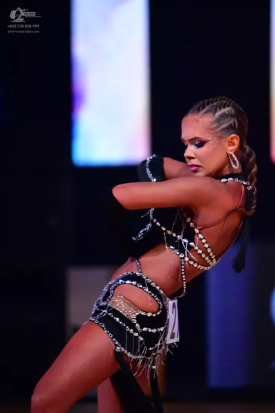 Dancesport competitor: Female dancer: black Latin dance costume with silver rhinestones and cutout desi